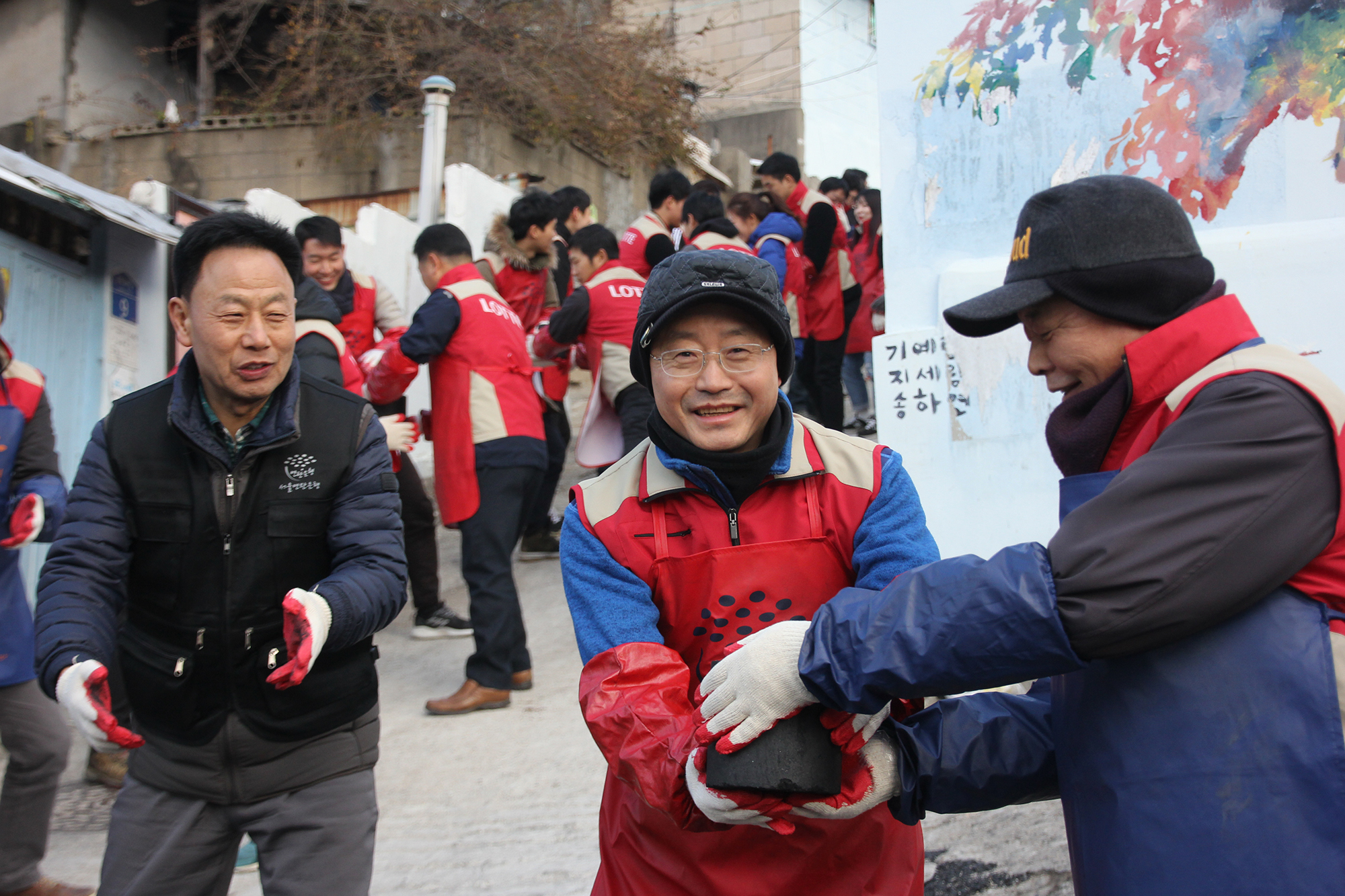 하석주 대표이사가 롯데건설 샤롯데 봉사단과 함께 연탄을 나르고 있다.JPG