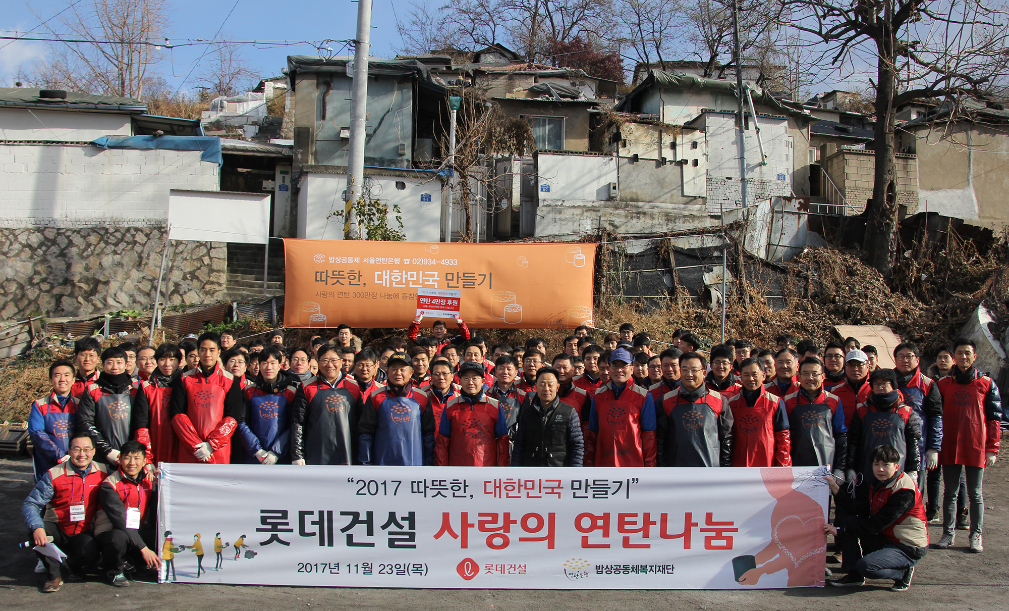 롯데건설 임직원들이 연탄나눔 봉사활동 단체촬영을 하고 있다.JPG